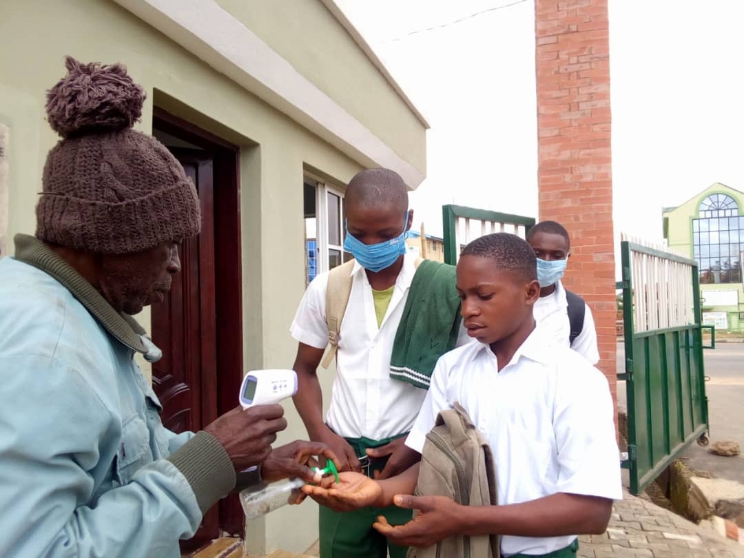 Students of Oyemekun Grammar School, Akure receiving sanitiser after being tested for COVID-19