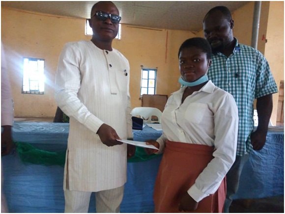 Principal of Ejioba High School, Oba-Ile, Dr Toyin Olobayo, presenting cash gift to best student in English in SS 3, Adesina Adetoun during the prize giving day of the school