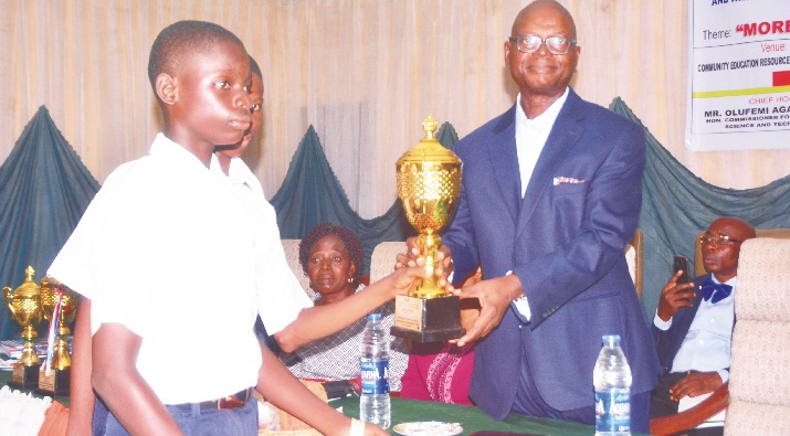 Ondo State Commissioner for Education, Science and Technology, Pastor Femi Agagu presenting an award to a student of Oloroke Grammar School, Oke Igbo  					Photo: Suberu Ayodele