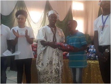 Yeye Otunba Aramide Ojo (M), presenting a gift to student with the best academic performance, Ibrahim Ojo, while others watch