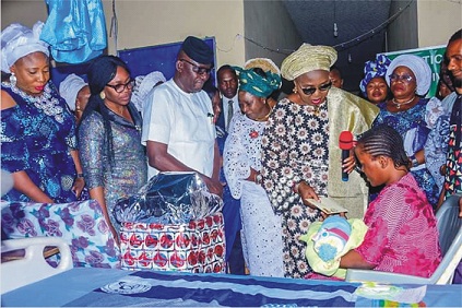 Wife of Ondo State Governor, Chief (Mrs) Betty Anyanwu-Akeredolu (R), presenting cash and gift items to one of the mothers. With her are; Commissioner for Health, Dr Banji Awolowo Ajaka (M) and others
