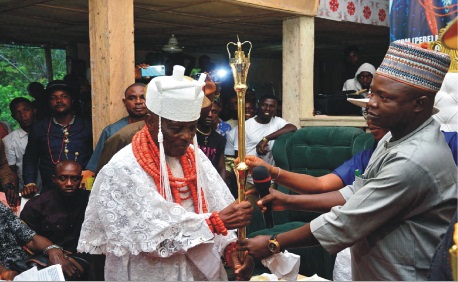 From left: The Amanana-Owei of Biagbini Clan in Ese-Odo Local Government, Oba  Pere Moses Igeiyobaghi Uguoji, receiving his Staff of Office, from Commissioner for Local Government and Chieftaincy Affairs, Alhaji Amidu Takuro at the ceremony