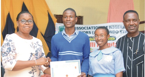 Deputy Director, Ondo State Ministry of Education, Mrs Folake Mapayi who represented Education Commissioner, presenting Certificate to Students of St Peter's Unity Secondary School, Akure who came first in a quiz competition, while Chairman, ANA in Ondo State, Mr Sunday Afolayan watches at the event               	       Photo: Stephen Olajide